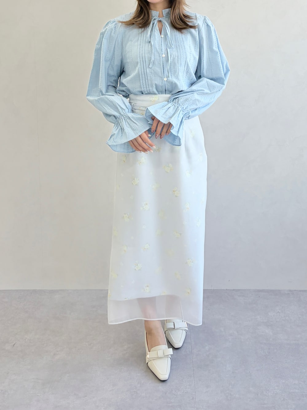 グレー系のスカート、ブルー系のシャツ/ブラウスを着用したレディースの春コーディネートの3枚目の写真