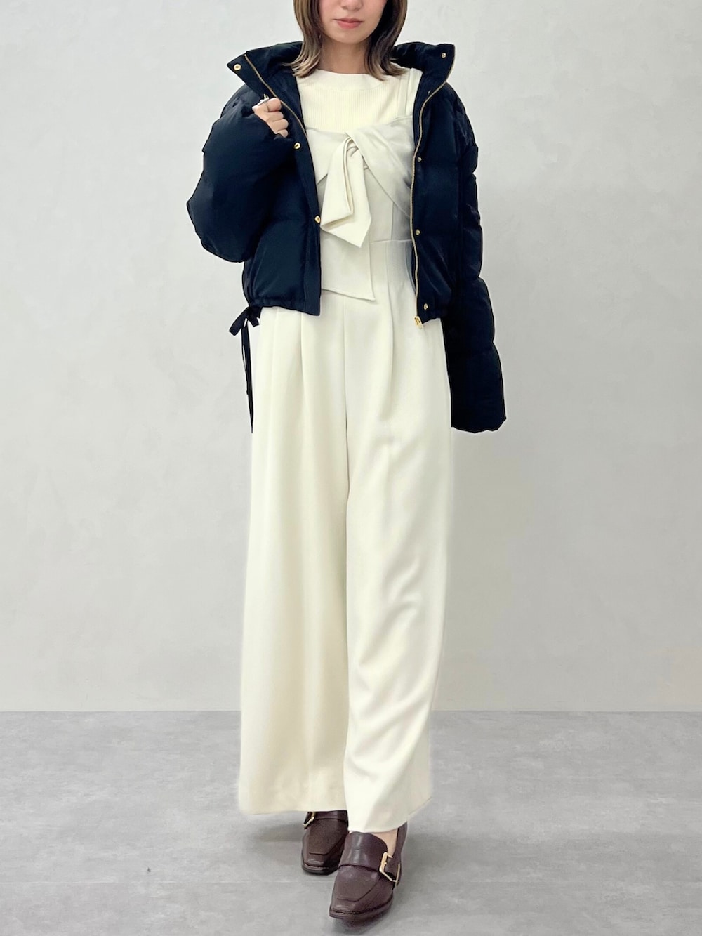 ホワイト系のサロペット/オーバーオール、ホワイト系のダウンジャケット/コートを着用したレディースの秋コーディネートの2枚目の写真