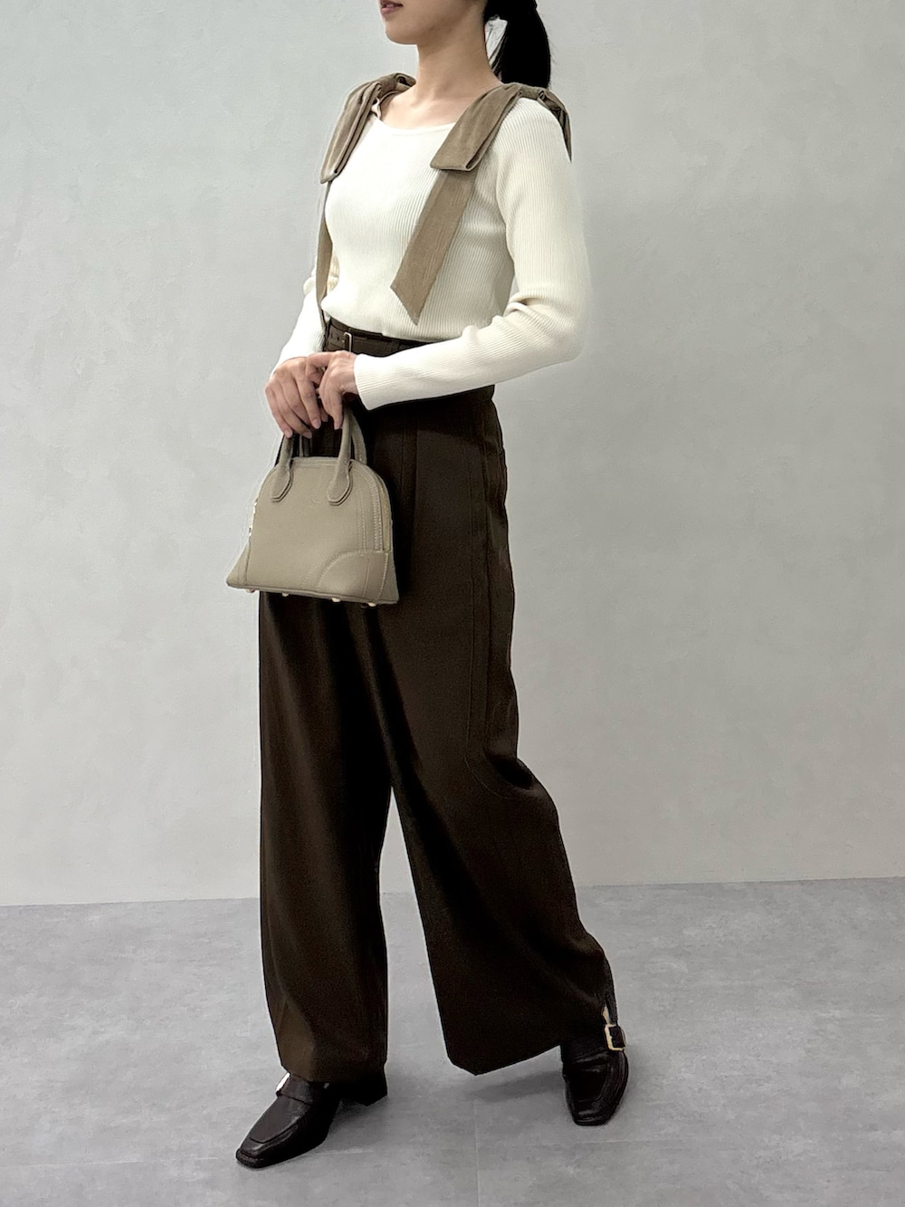 ベージュ系のニット/セーター、ブラウン系のスラックス、ブラウン系のパンプスを着用したレディースの秋コーディネートの3枚目の写真