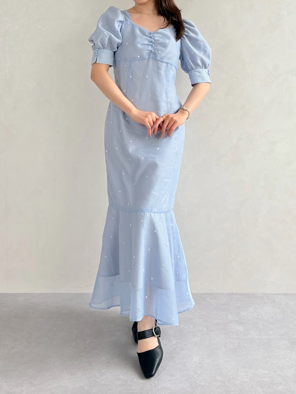 ブラック系のパンプス、ブルー系のワンピース、ブルー系のトレンチコートを着用したレディースの春コーディネートの4枚目の写真