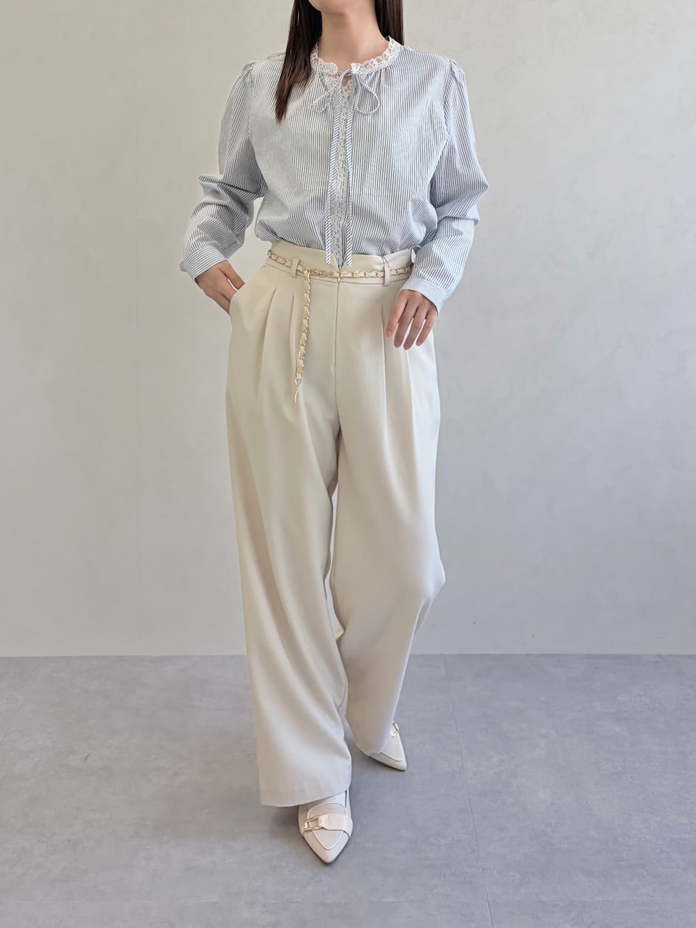 ブルー系のシャツ/ブラウス、ベージュ系のスラックスを着用したレディースの春コーディネートの3枚目の写真