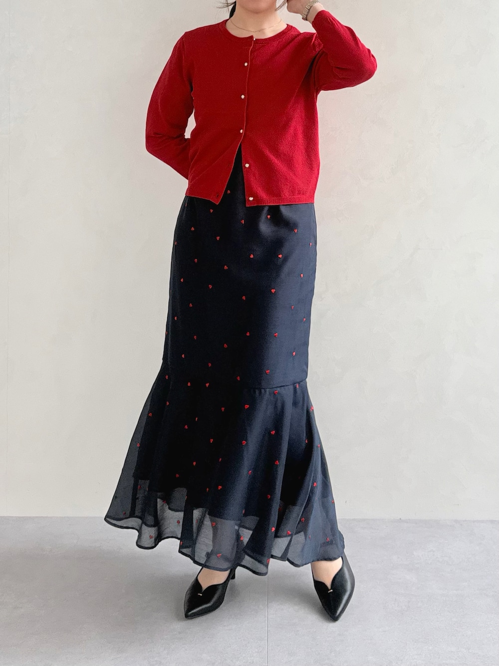 ブラック系のワンピース、レッド系のカーディガン/ボレロを着用したレディースの春コーディネートの3枚目の写真