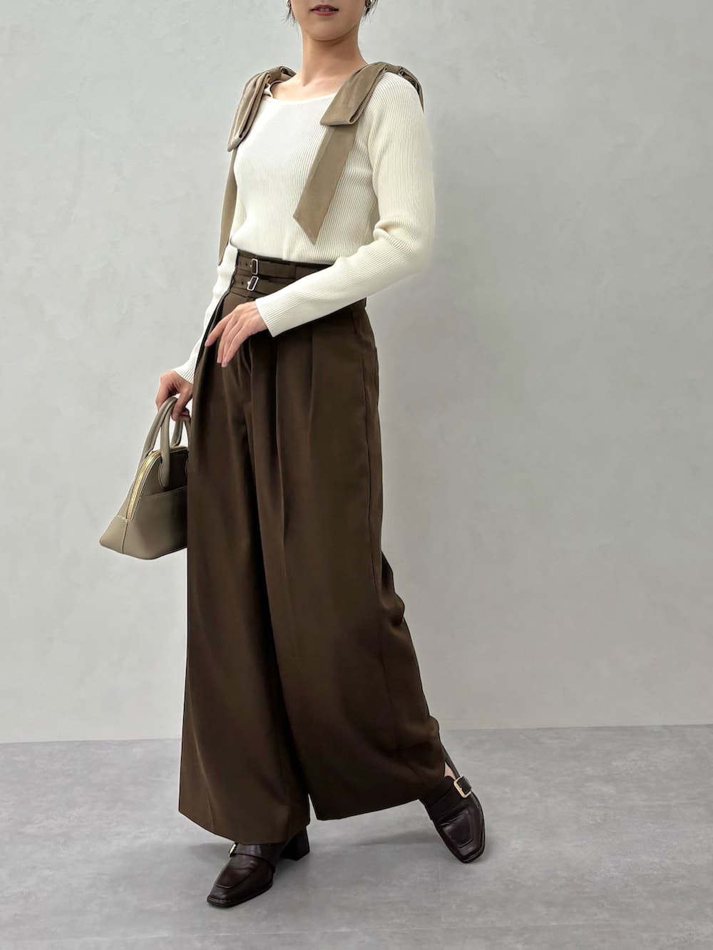 ベージュ系のニット/セーター、ブラウン系のスラックス、ブラウン系のパンプスを着用したレディースの秋コーディネートの2枚目の写真