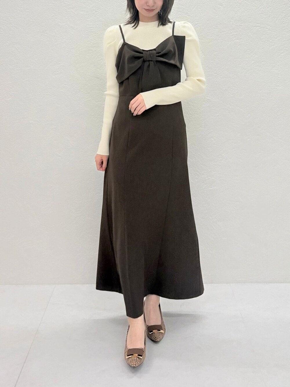 ブラウン系のジャンパースカートを着用したレディースの秋コーディネートの2枚目の写真