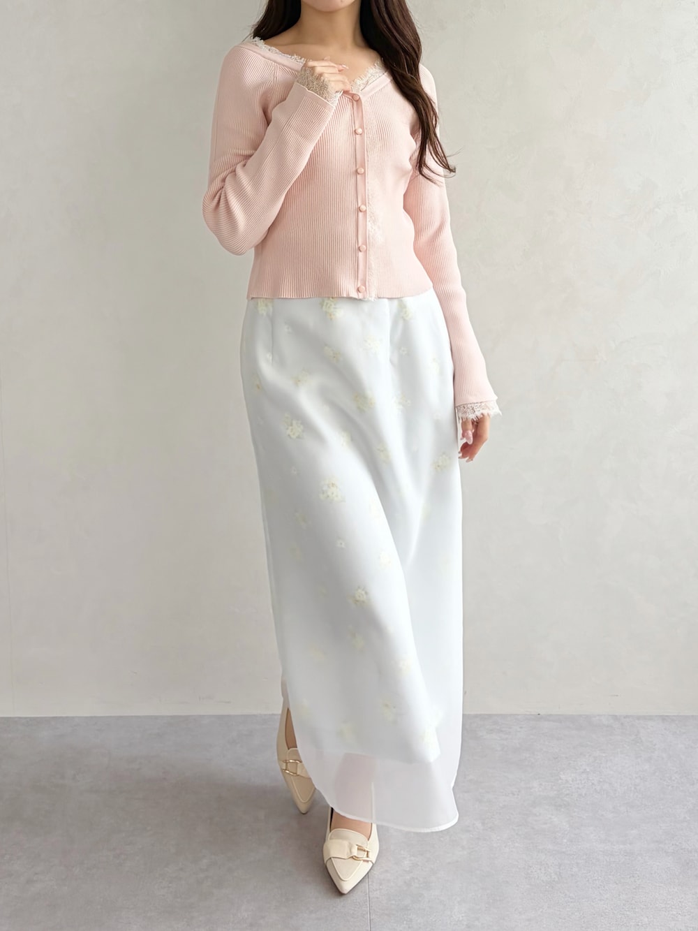 グレー系のスカート、ピンク系のニット/セーターを着用したレディースの春コーディネートの2枚目の写真