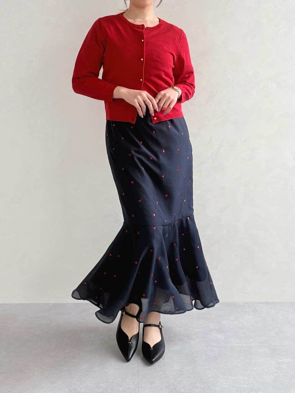 ブラック系のワンピース、レッド系のカーディガン/ボレロを着用したレディースの春コーディネートの4枚目の写真