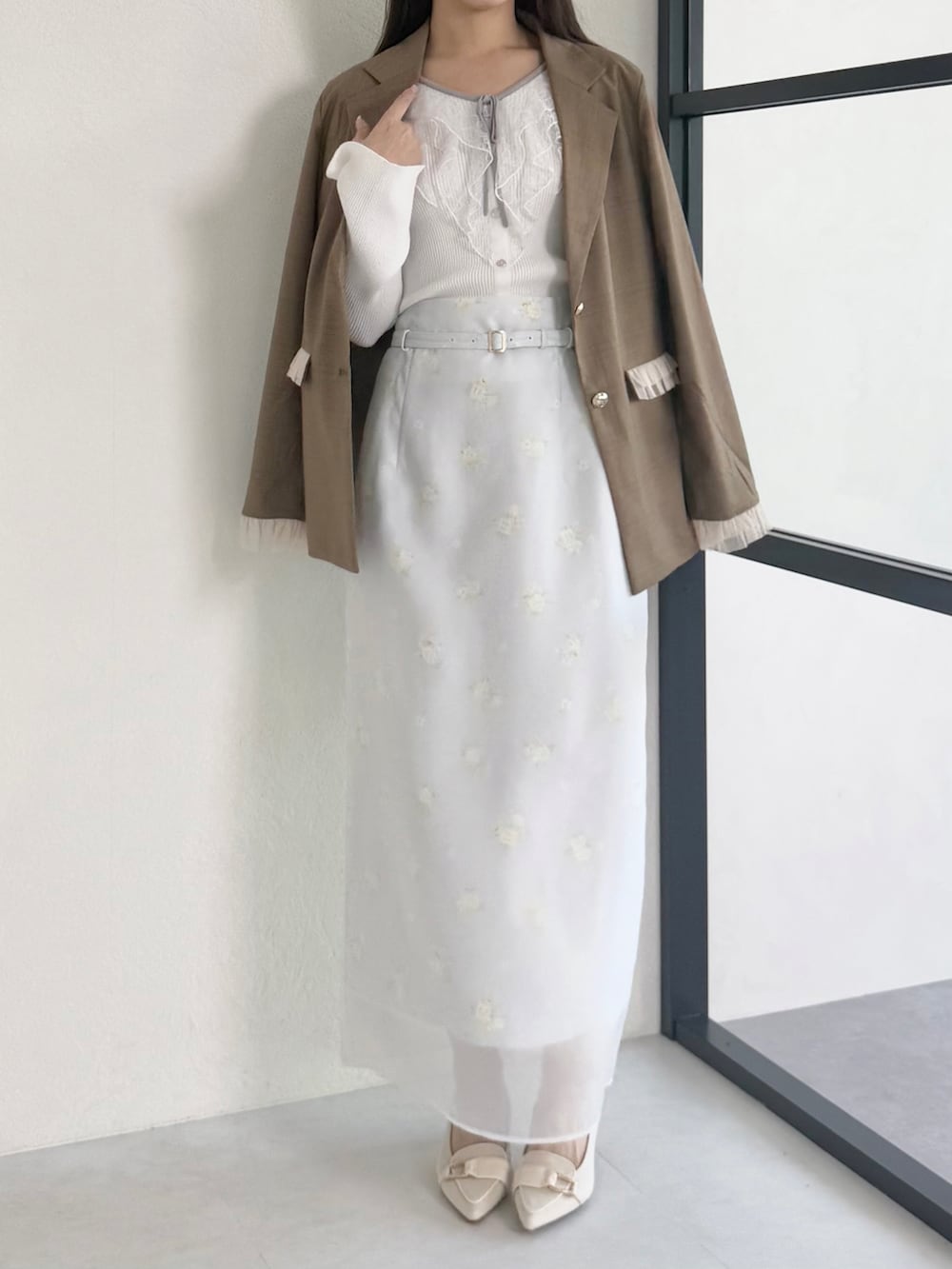 ブラウン系のテーラードジャケット、グレー系のスカート、ベージュ系のシューズを着用したレディースの春コーディネートの2枚目の写真