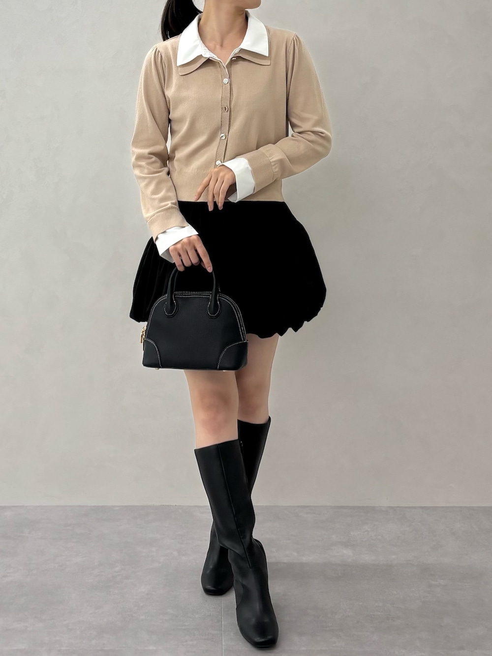 ベージュ系のニット/セーター、ブラック系のバッグを着用したレディースの秋コーディネートの3枚目の写真