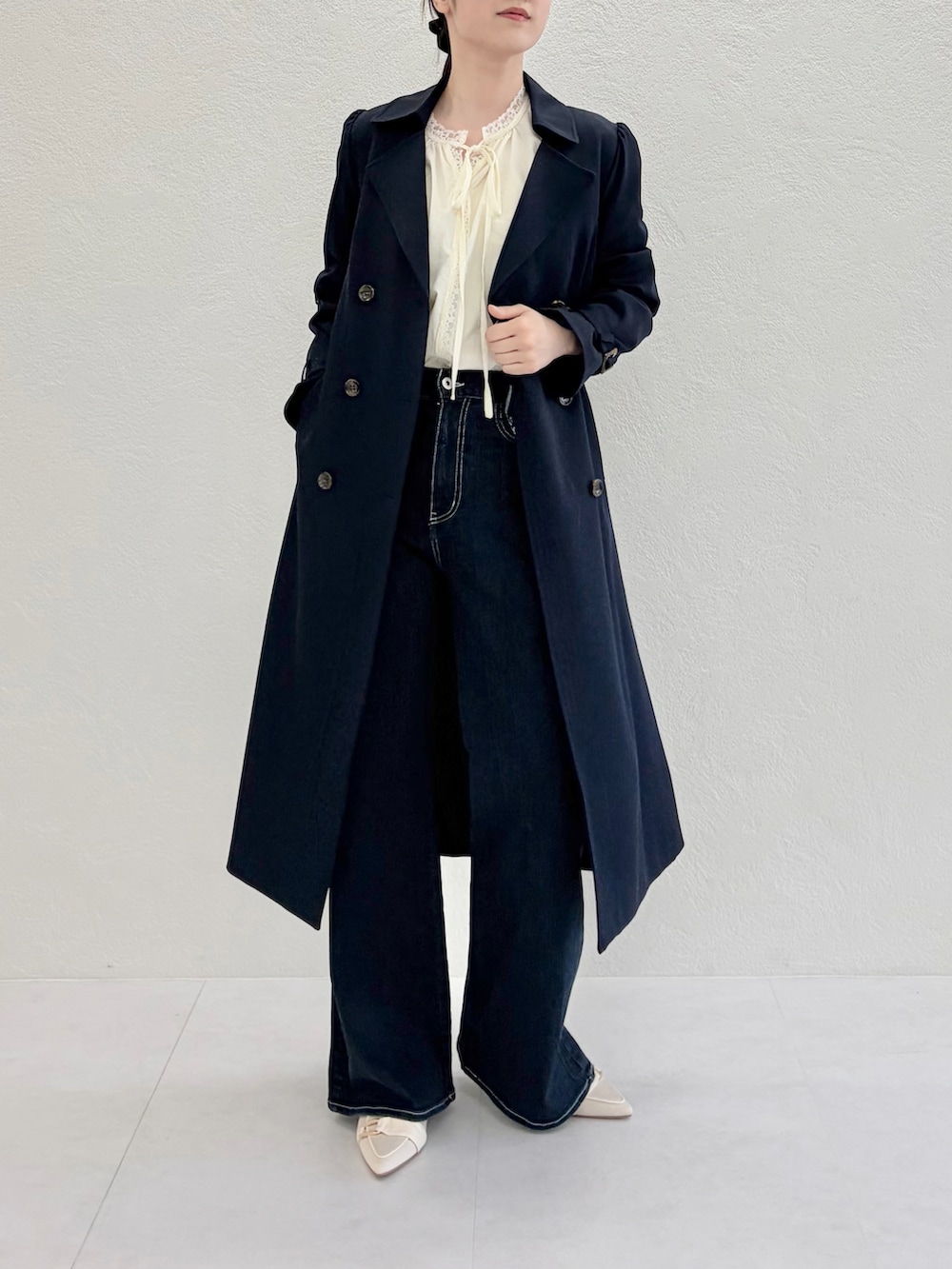 ブルー系のデニムパンツ、ブルー系のトレンチコート、イエロー系のシャツ/ブラウスを着用したレディースの春コーディネートの2枚目の写真