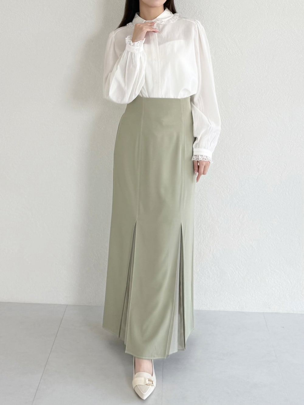 グリーン系のスカート、ベージュ系のシューズ、ホワイト系のシャツ/ブラウスを着用したレディースの春コーディネートの2枚目の写真