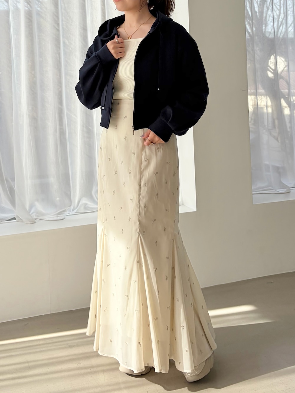 ブルー系のパーカー、ベージュ系のスニーカー、ホワイト系のスカートを着用したレディースの春コーディネートの3枚目の写真