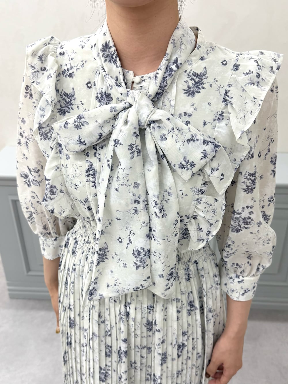 グリーン系のワンピース、ブラック系のバッグ、ベージュ系のパンプスを着用したレディースの秋コーディネートの5枚目の写真