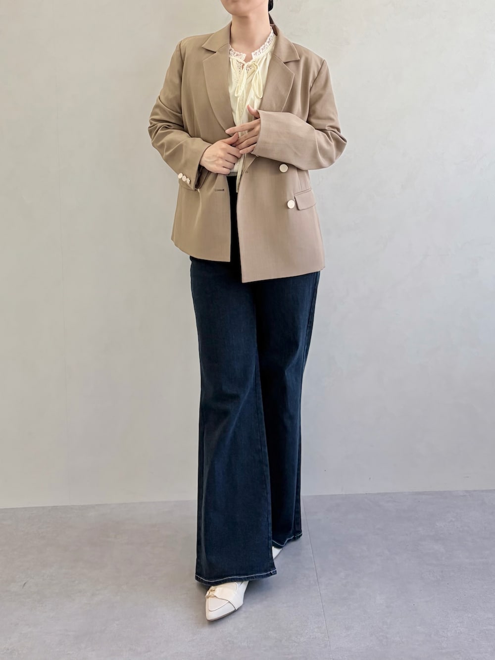 ブルー系のデニムパンツ、ブラウン系のテーラードジャケット、イエロー系のシャツ/ブラウスを着用したレディースの春コーディネートの4枚目の写真