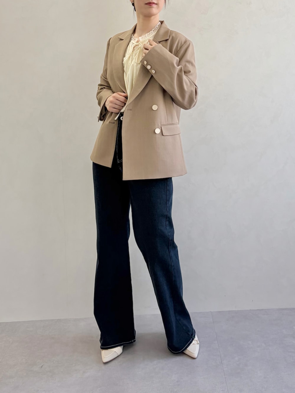 ブルー系のデニムパンツ、ブラウン系のテーラードジャケット、イエロー系のシャツ/ブラウスを着用したレディースの春コーディネートの3枚目の写真