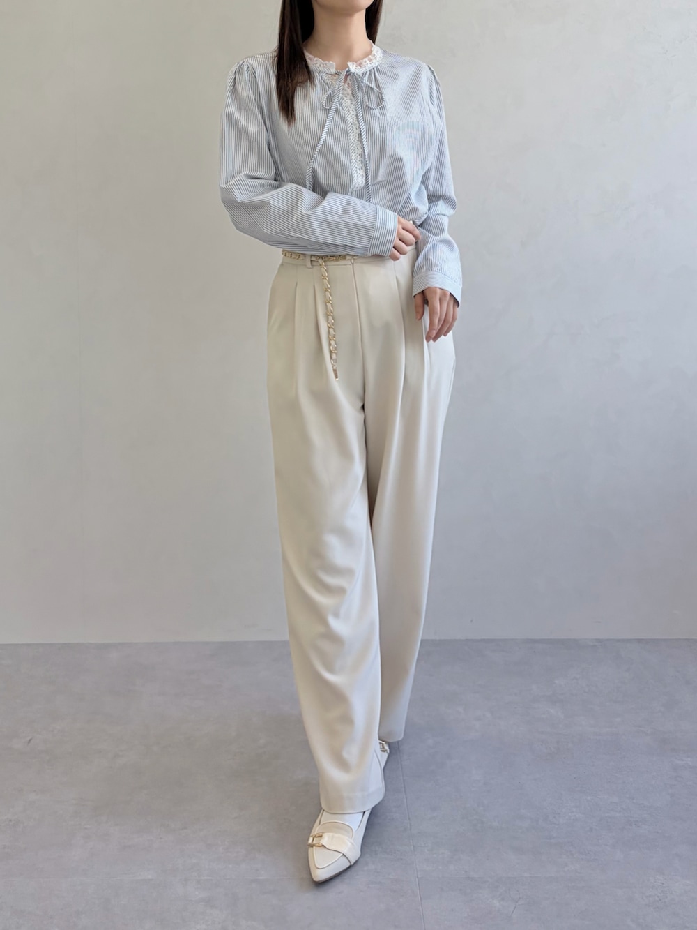 ブルー系のシャツ/ブラウス、ベージュ系のスラックスを着用したレディースの春コーディネートの5枚目の写真