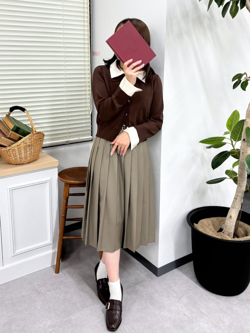 ブラウン系のニット/セーター、ベージュ系のスカート、ブラウン系のパンプスを着用したレディースの秋コーディネートの2枚目の写真