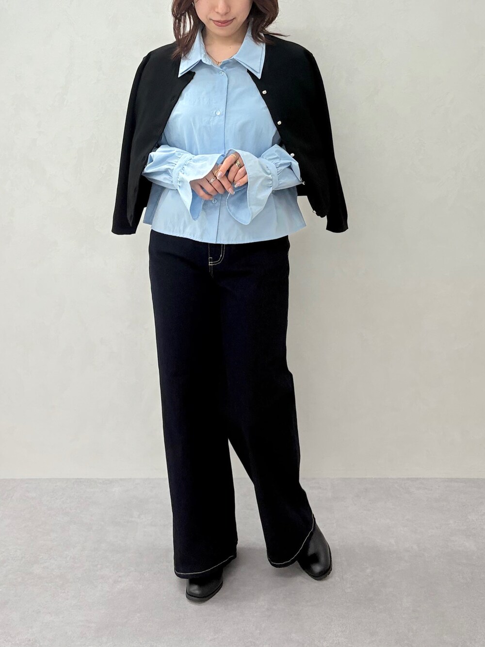 ブルー系のデニムパンツ、ブラック系のカーディガン/ボレロ、ブルー系のシャツ/ブラウスを着用したレディースの秋コーディネートの3枚目の写真
