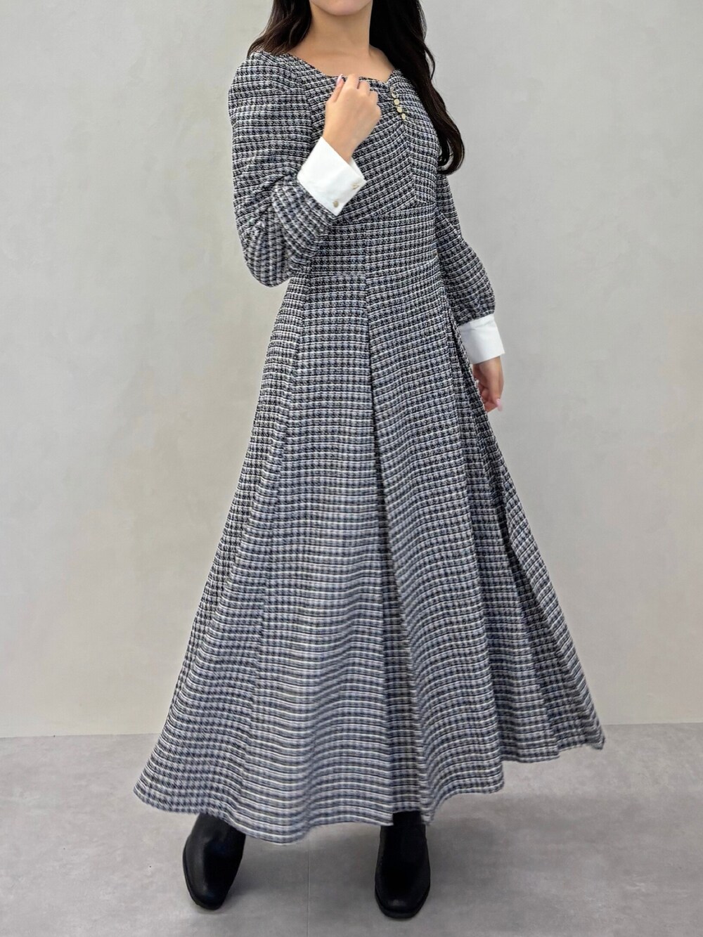 ブラック系のワンピースを着用したレディースの冬コーディネートの2枚目の写真