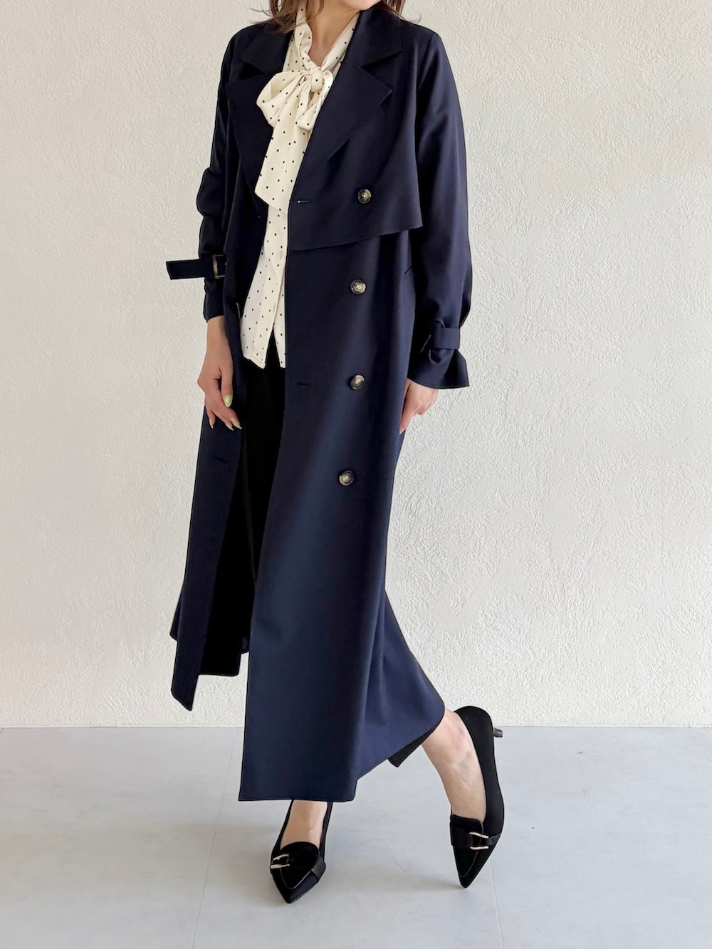 ブルー系のトレンチコート、ブラック系のその他パンツ、ホワイト系のシャツ/ブラウスを着用したレディースの春コーディネートの2枚目の写真