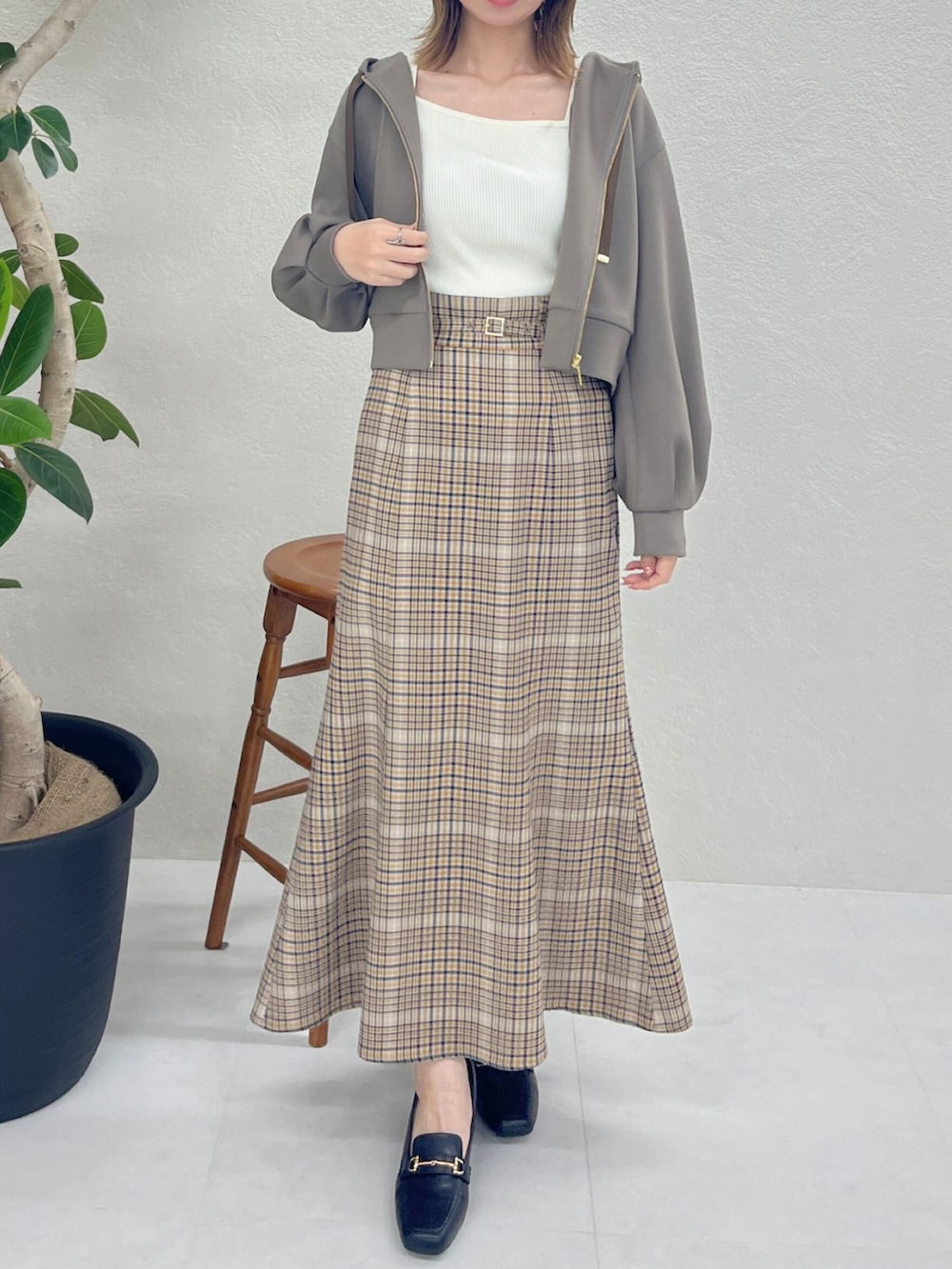 ブラウン系のパーカー、ベージュ系のスカート、ブラック系のバッグを着用したレディースの秋コーディネートの3枚目の写真