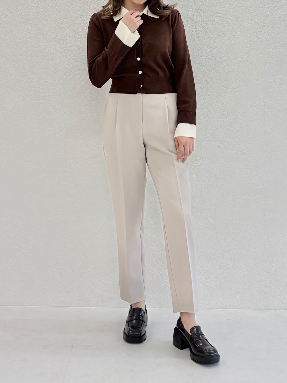 ベージュ系のニット/セーター、ブラック系のその他パンツ、ブラウン系のローファーを着用したレディースの春コーディネートの2枚目の写真