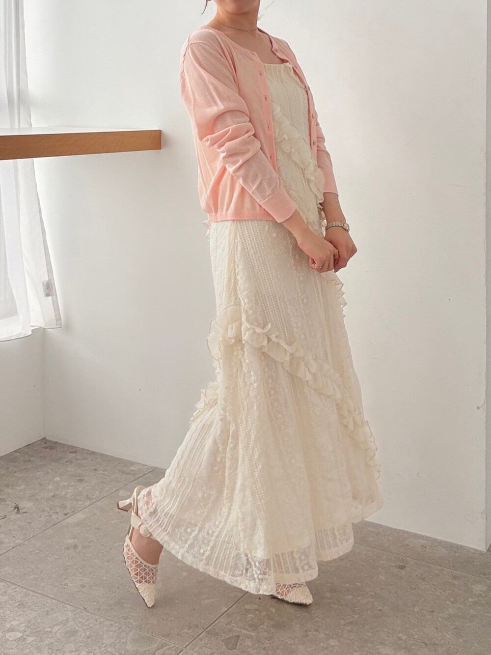 ホワイト系のワンピース、ピンク系のカーディガン/ボレロを着用したレディースの春コーディネートの2枚目の写真