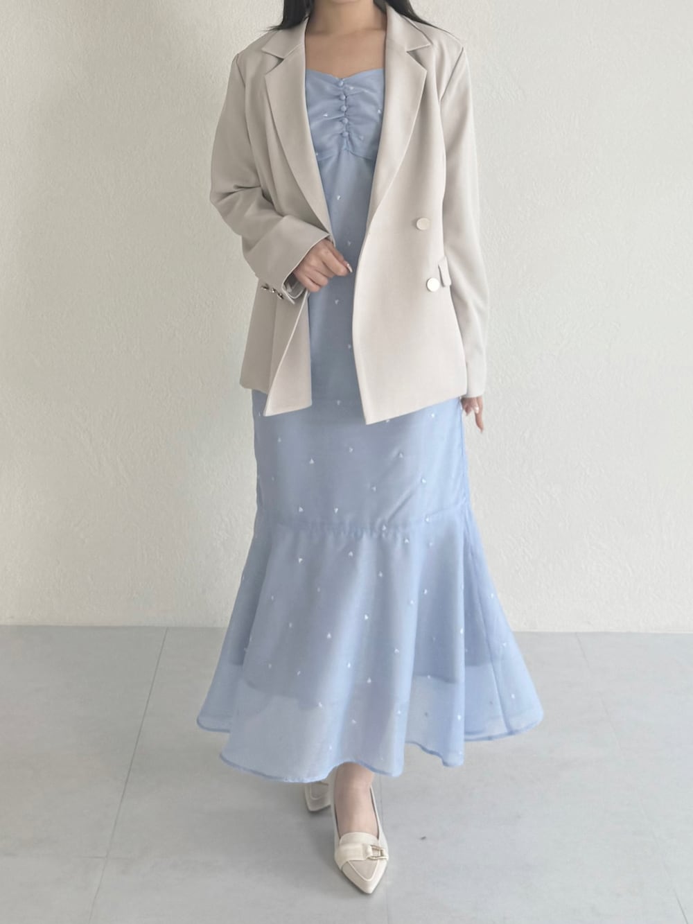 ブルー系のワンピース、ベージュ系のシューズ、ベージュ系のテーラードジャケットを着用したレディースの春コーディネートの3枚目の写真