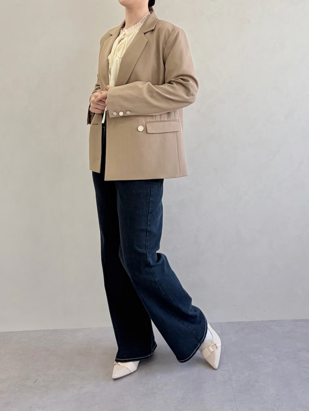 ブルー系のデニムパンツ、ブラウン系のテーラードジャケット、イエロー系のシャツ/ブラウスを着用したレディースの春コーディネートの2枚目の写真