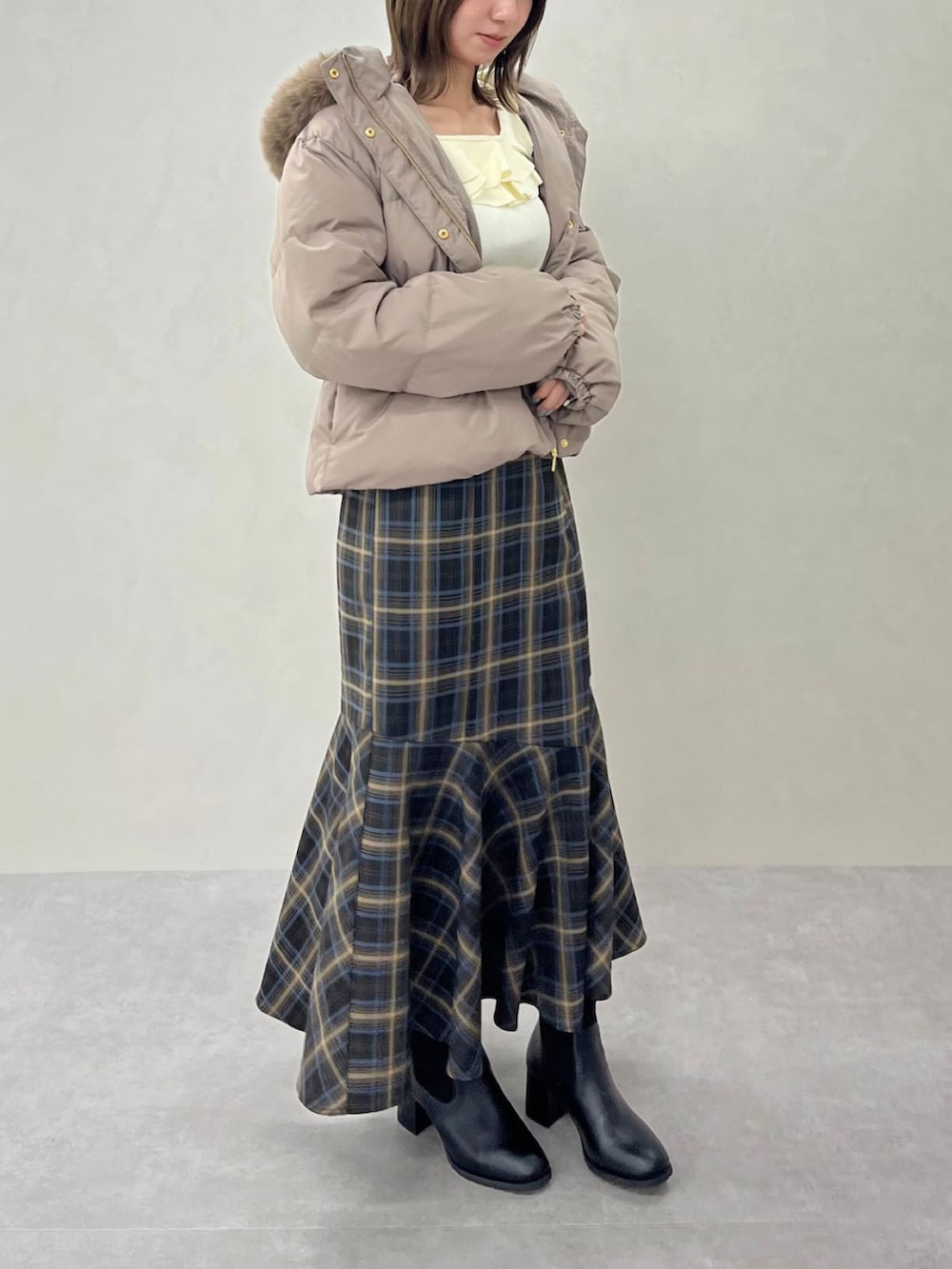 ブルー系のスカート、ホワイト系のニット/セーターを着用したレディースの秋コーディネートの4枚目の写真