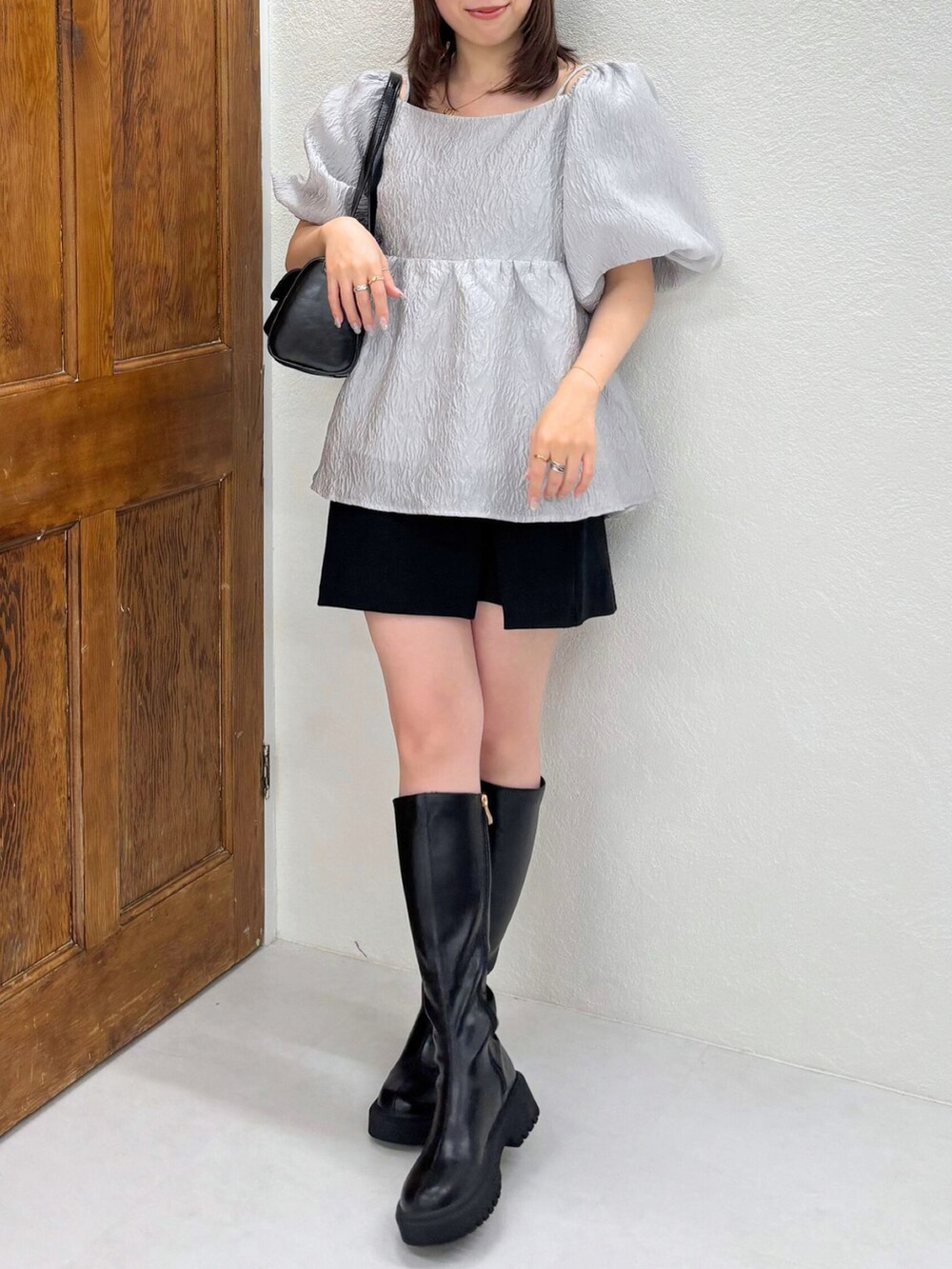 ブラック系のショルダーバッグ、ブラック系のブーツ、ブラック系のシャツ/ブラウスを着用したレディースの秋コーディネートの2枚目の写真