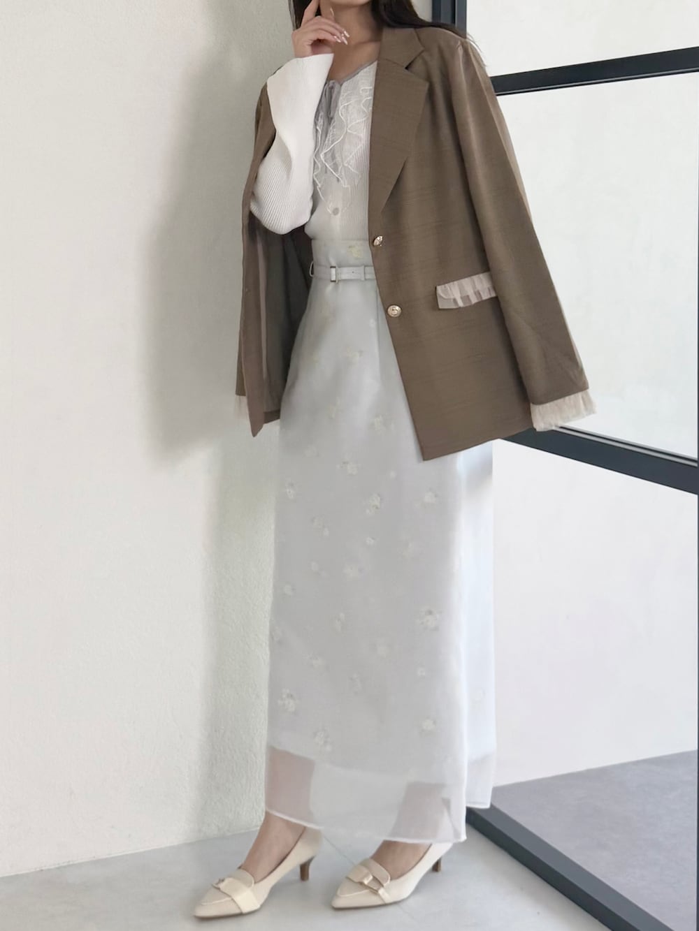 ブラウン系のテーラードジャケット、グレー系のスカート、ベージュ系のシューズを着用したレディースの春コーディネートの3枚目の写真