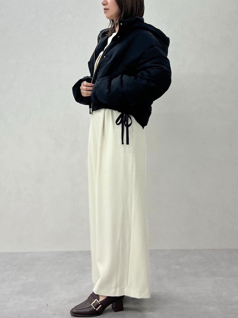 ホワイト系のサロペット/オーバーオール、ホワイト系のダウンジャケット/コートを着用したレディースの秋コーディネートの3枚目の写真
