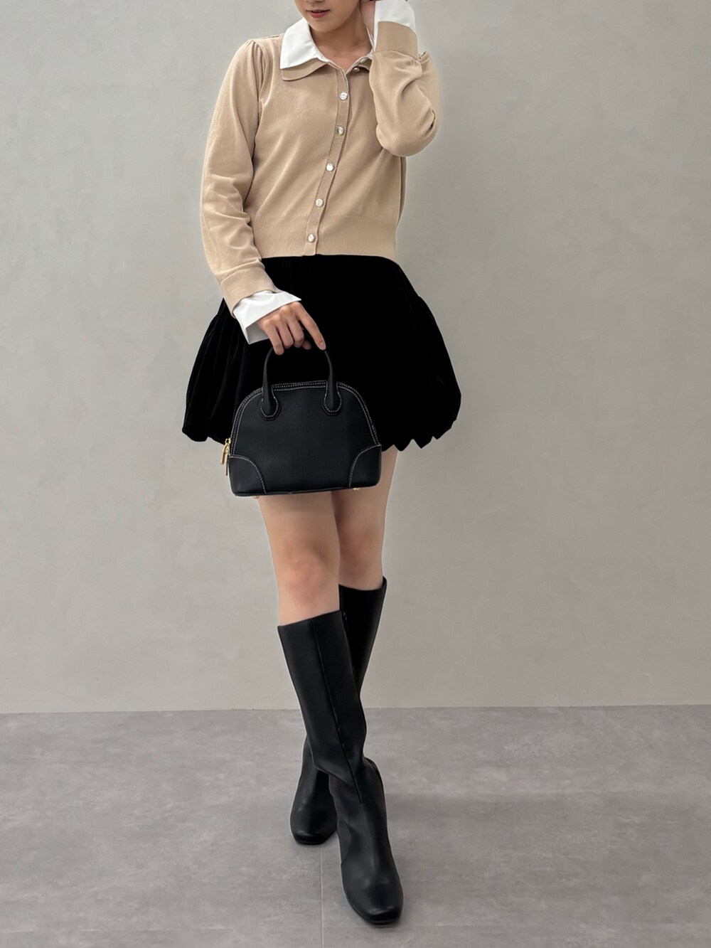 ベージュ系のニット/セーター、ブラック系のバッグを着用したレディースの秋コーディネートの2枚目の写真