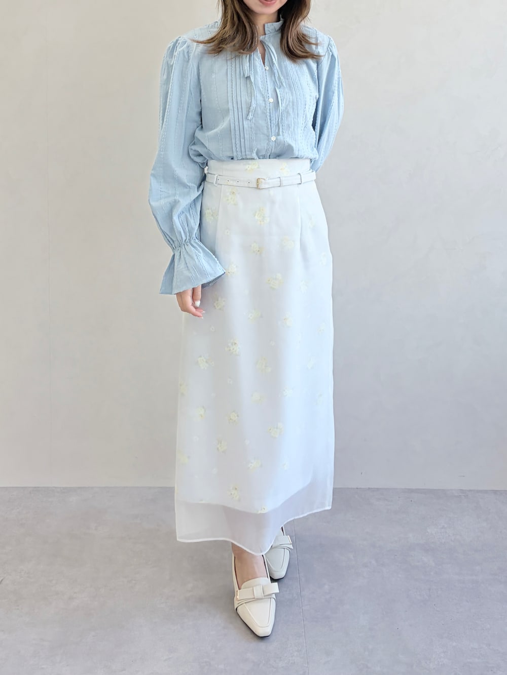 グレー系のスカート、ブルー系のシャツ/ブラウスを着用したレディースの春コーディネートの2枚目の写真