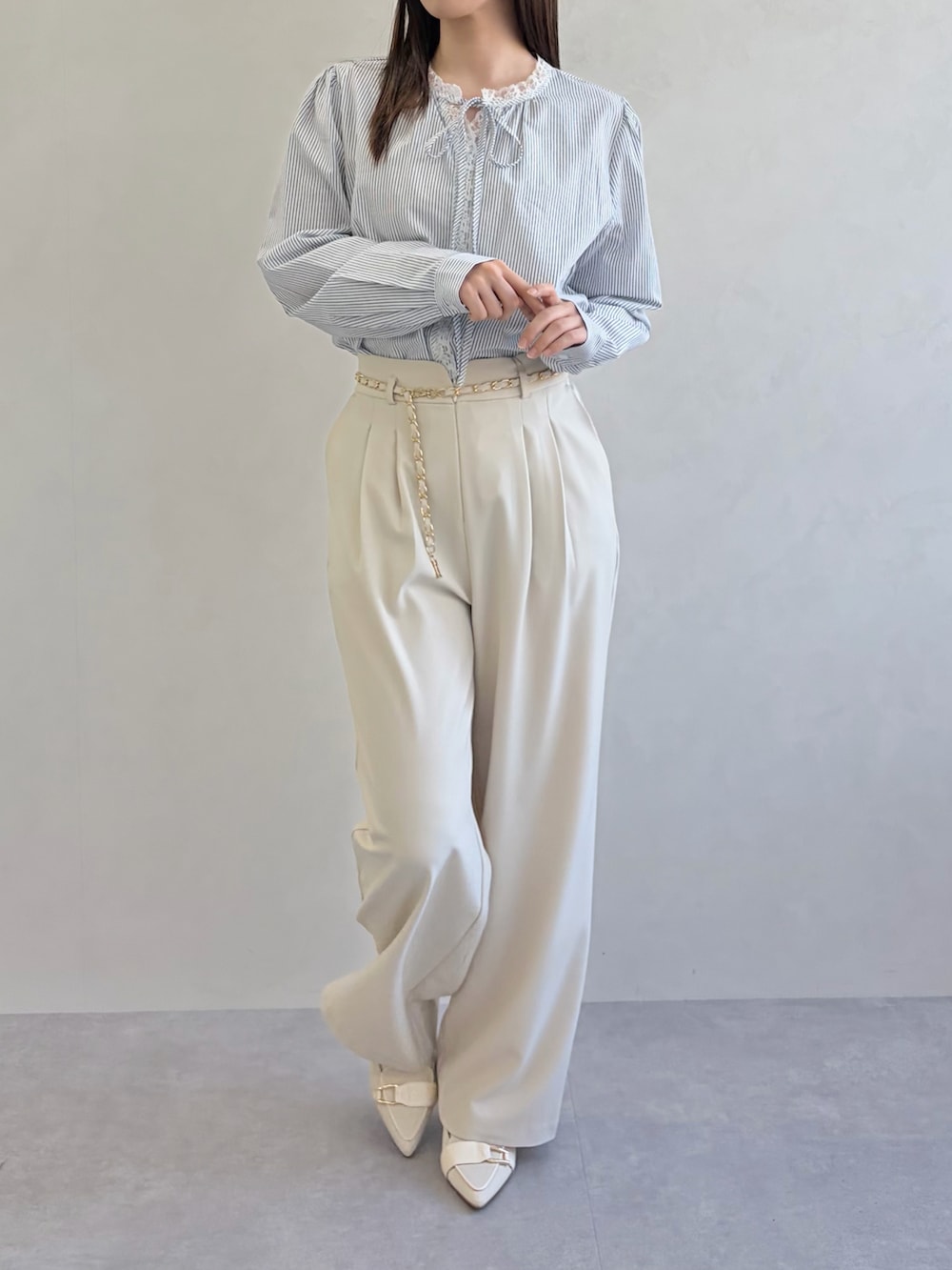 ブルー系のシャツ/ブラウス、ベージュ系のスラックスを着用したレディースの春コーディネートの4枚目の写真