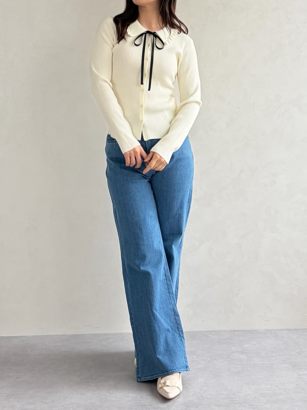 ブルー系のデニムパンツ、ホワイト系のニット/セーターを着用したレディースの春コーディネートの3枚目の写真