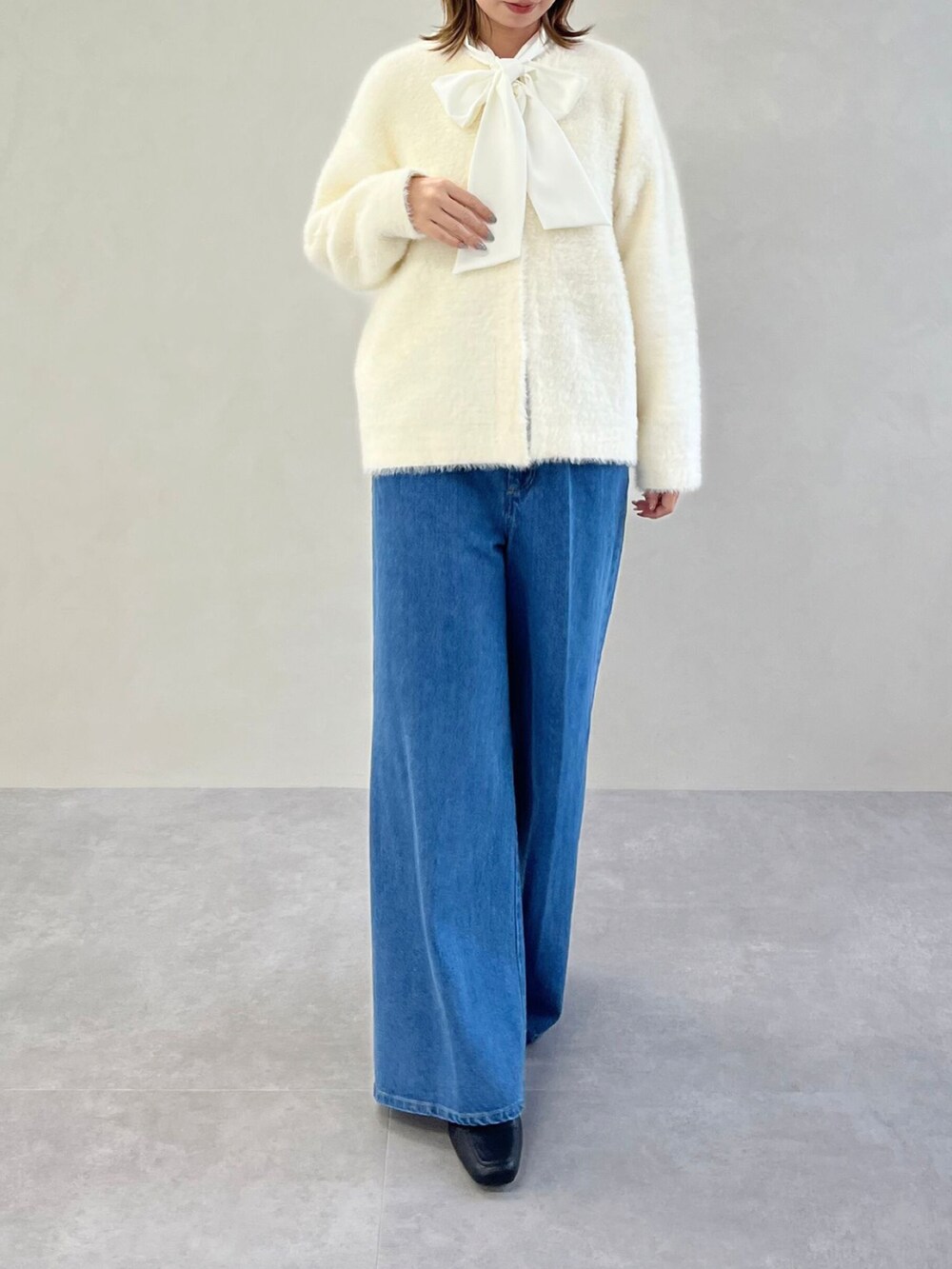 ホワイト系のシャツ/ブラウス、ブラウン系のカーディガン/ボレロ、ブルー系のデニムパンツを着用したレディースの秋コーディネートの2枚目の写真