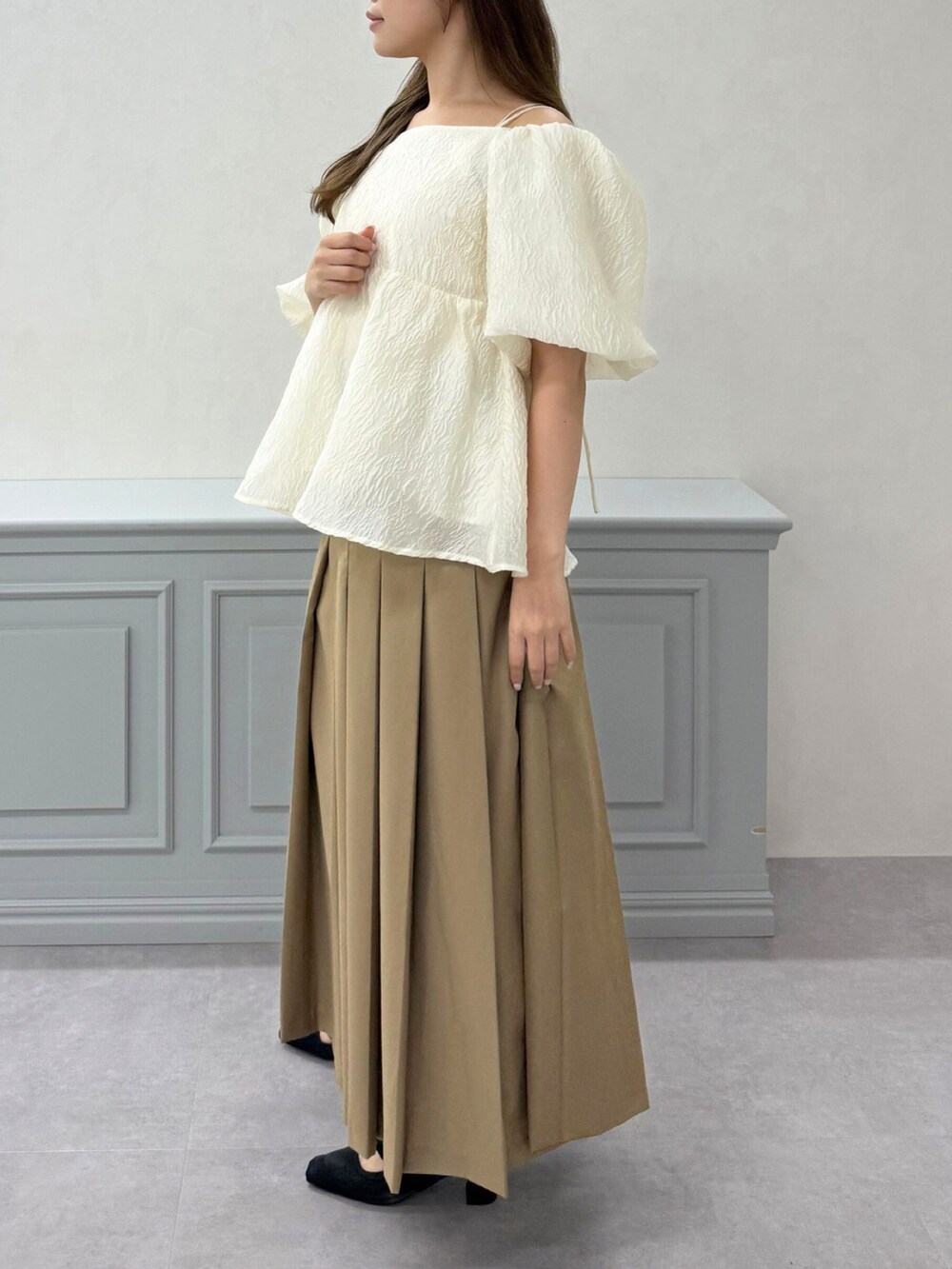 ホワイト系のシャツ/ブラウス、イエロー系のスカート、ブラック系のパンプスを着用したレディースの秋コーディネートの4枚目の写真