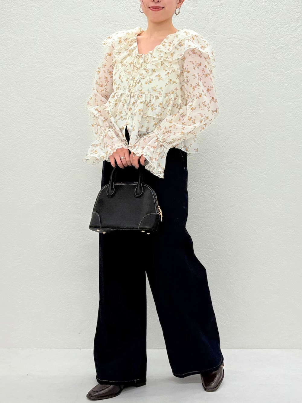 ブラウン系のパンプス、ベージュ系のシャツ/ブラウス、ブルー系のデニムパンツを着用したレディースの秋コーディネートの3枚目の写真