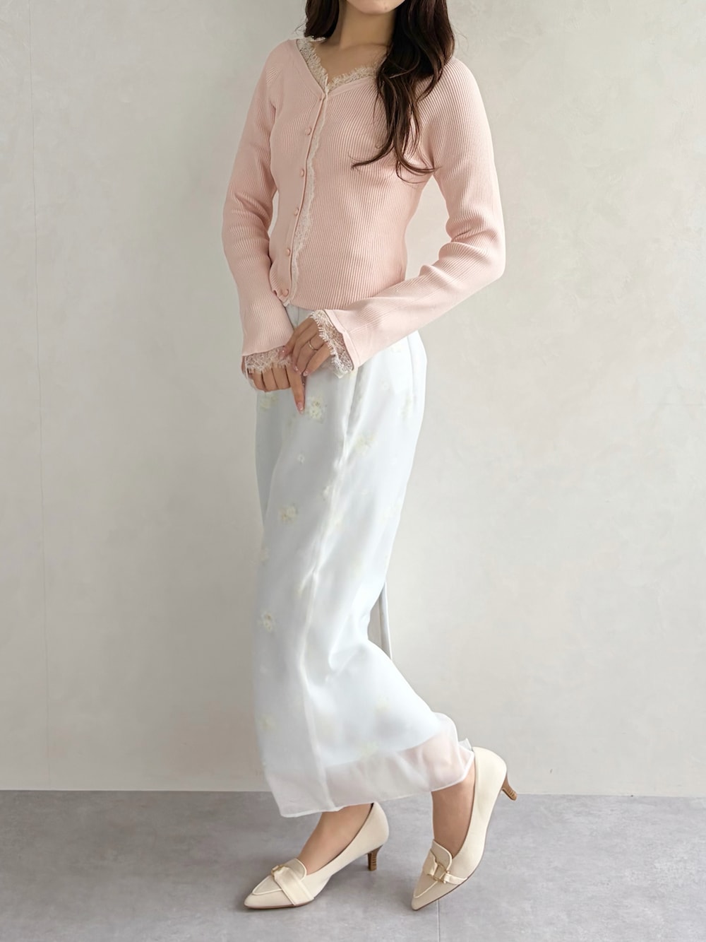 グレー系のスカート、ピンク系のニット/セーターを着用したレディースの春コーディネートの3枚目の写真