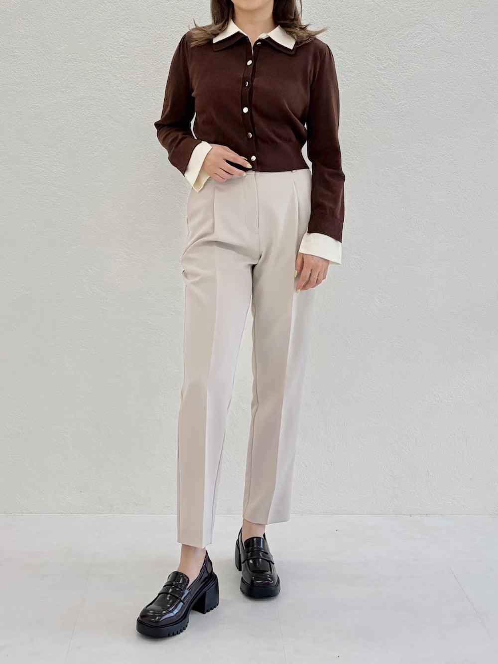 ベージュ系のニット/セーター、ブラック系のその他パンツ、ブラウン系のローファーを着用したレディースの春コーディネートの3枚目の写真