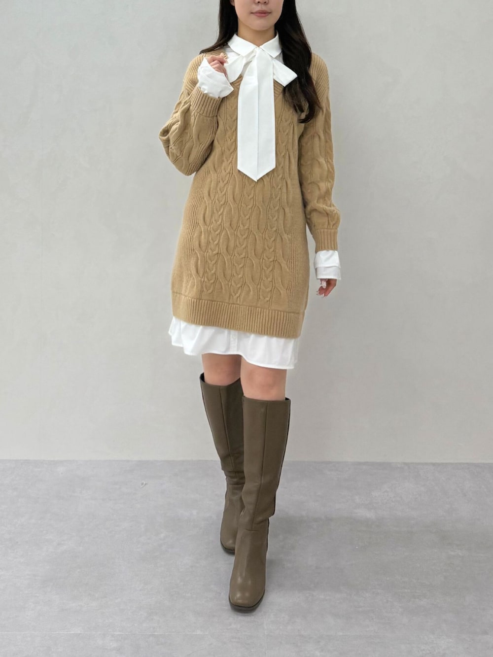 イエロー系のワンピース、ブラック系のブーツを着用したレディースの秋コーディネートの2枚目の写真