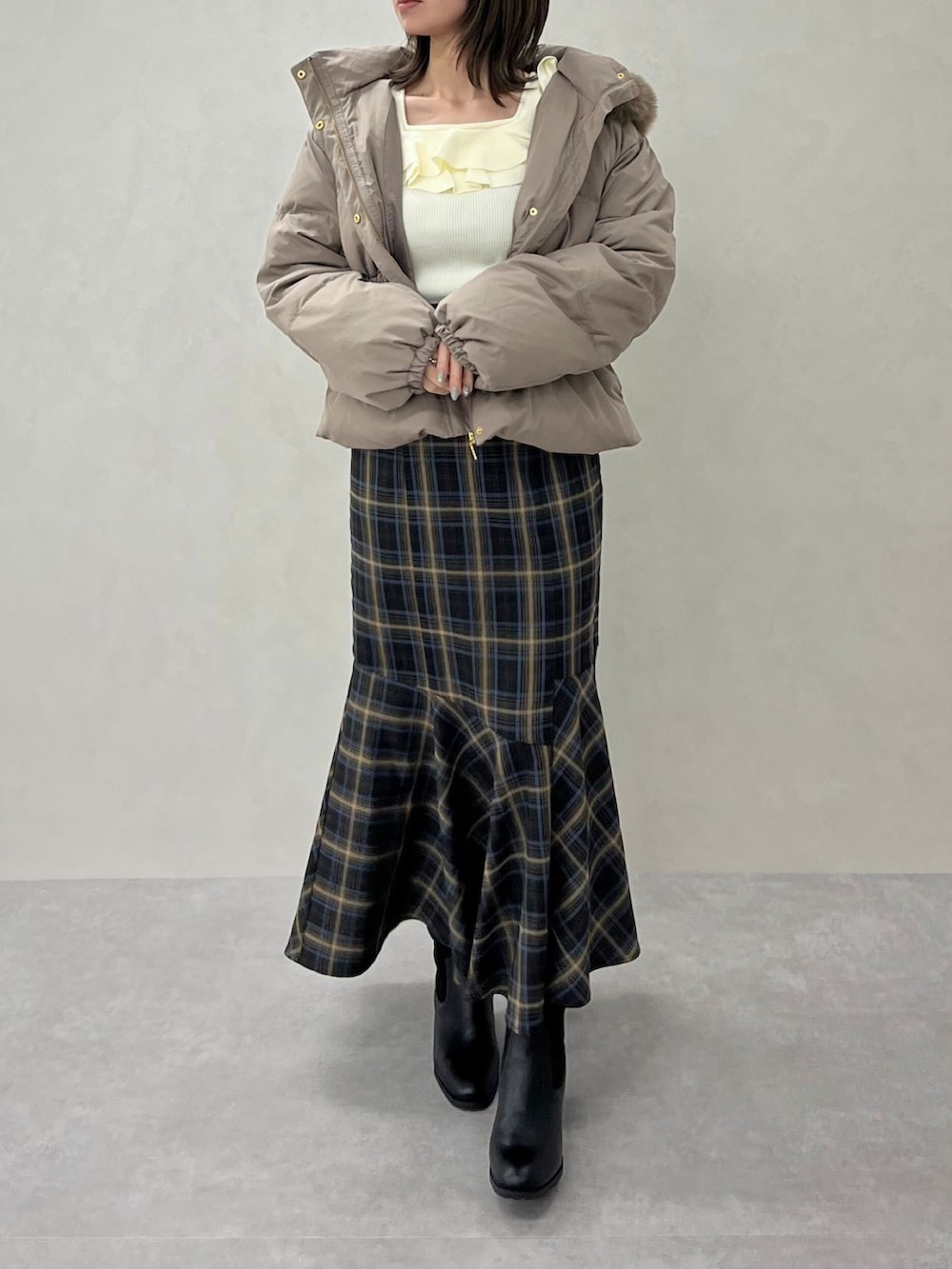 ブルー系のスカート、ホワイト系のニット/セーターを着用したレディースの秋コーディネートの3枚目の写真