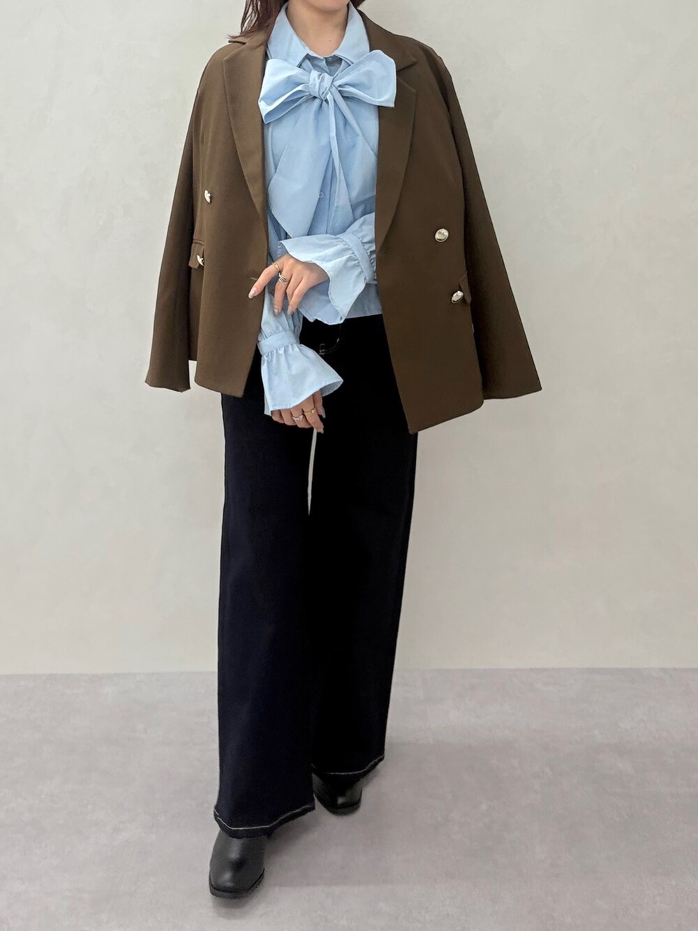 ベージュ系のテーラードジャケット、ブルー系のシャツ/ブラウスを着用したレディースの秋コーディネートの2枚目の写真