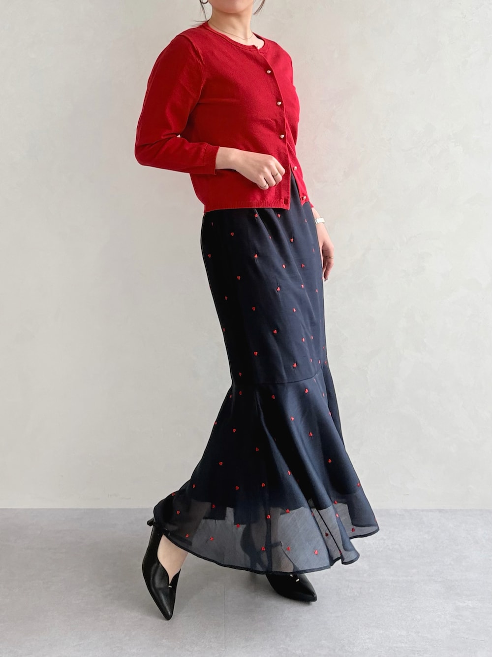 ブラック系のワンピース、レッド系のカーディガン/ボレロを着用したレディースの春コーディネートの2枚目の写真