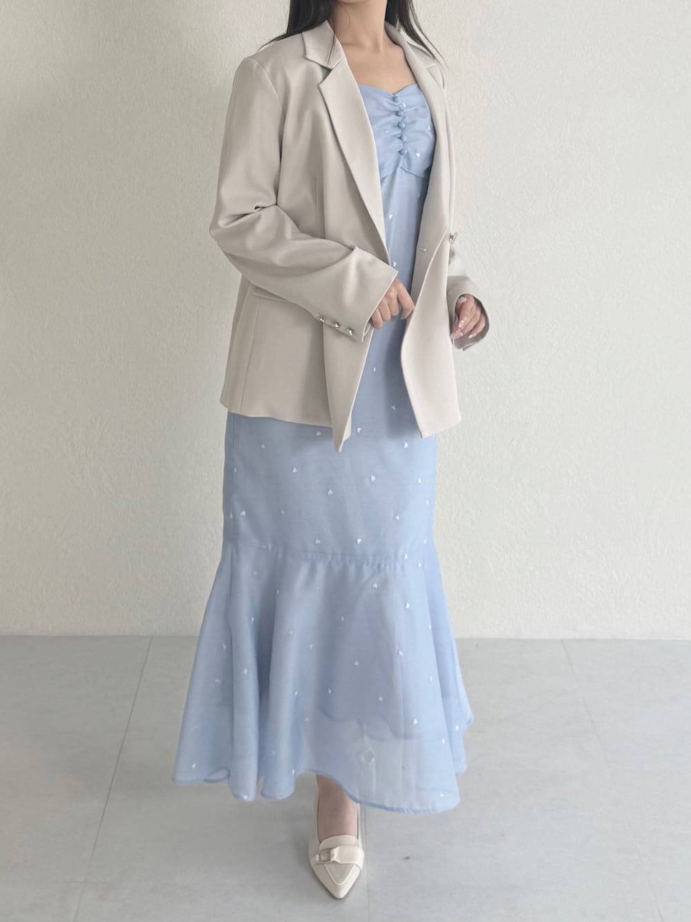 ブルー系のワンピース、ベージュ系のシューズ、ベージュ系のテーラードジャケットを着用したレディースの春コーディネートの2枚目の写真