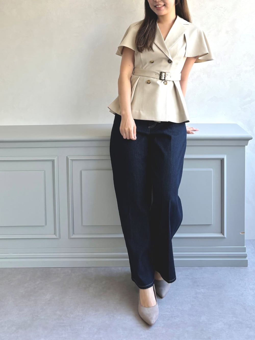 ベージュ系のベスト、ブルー系のデニムパンツ、グレー系のパンプスを着用したレディースの秋コーディネートの5枚目の写真