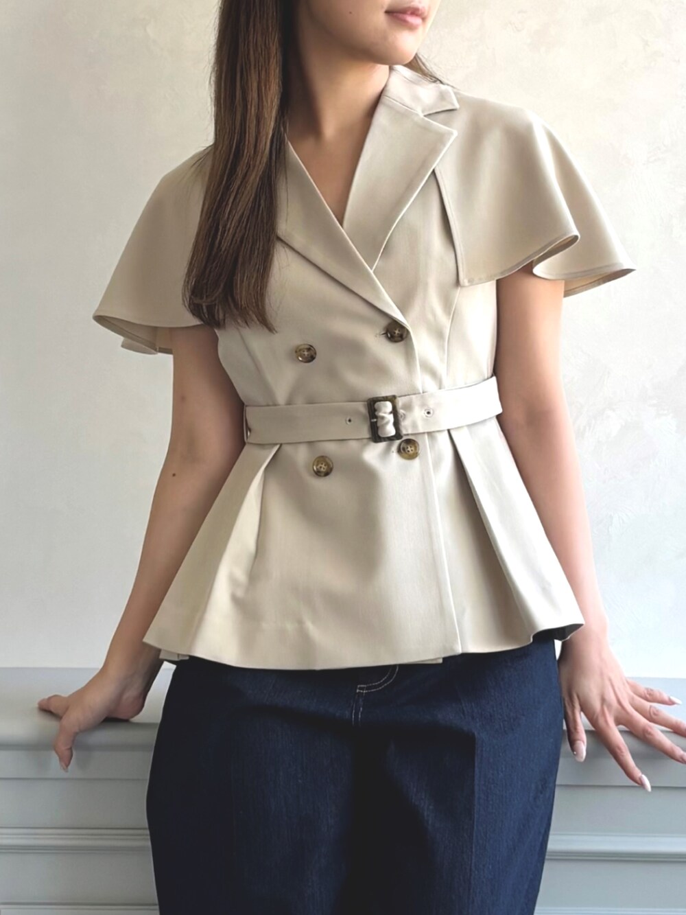 ベージュ系のベスト、ブルー系のデニムパンツ、グレー系のパンプスを着用したレディースの秋コーディネートの4枚目の写真