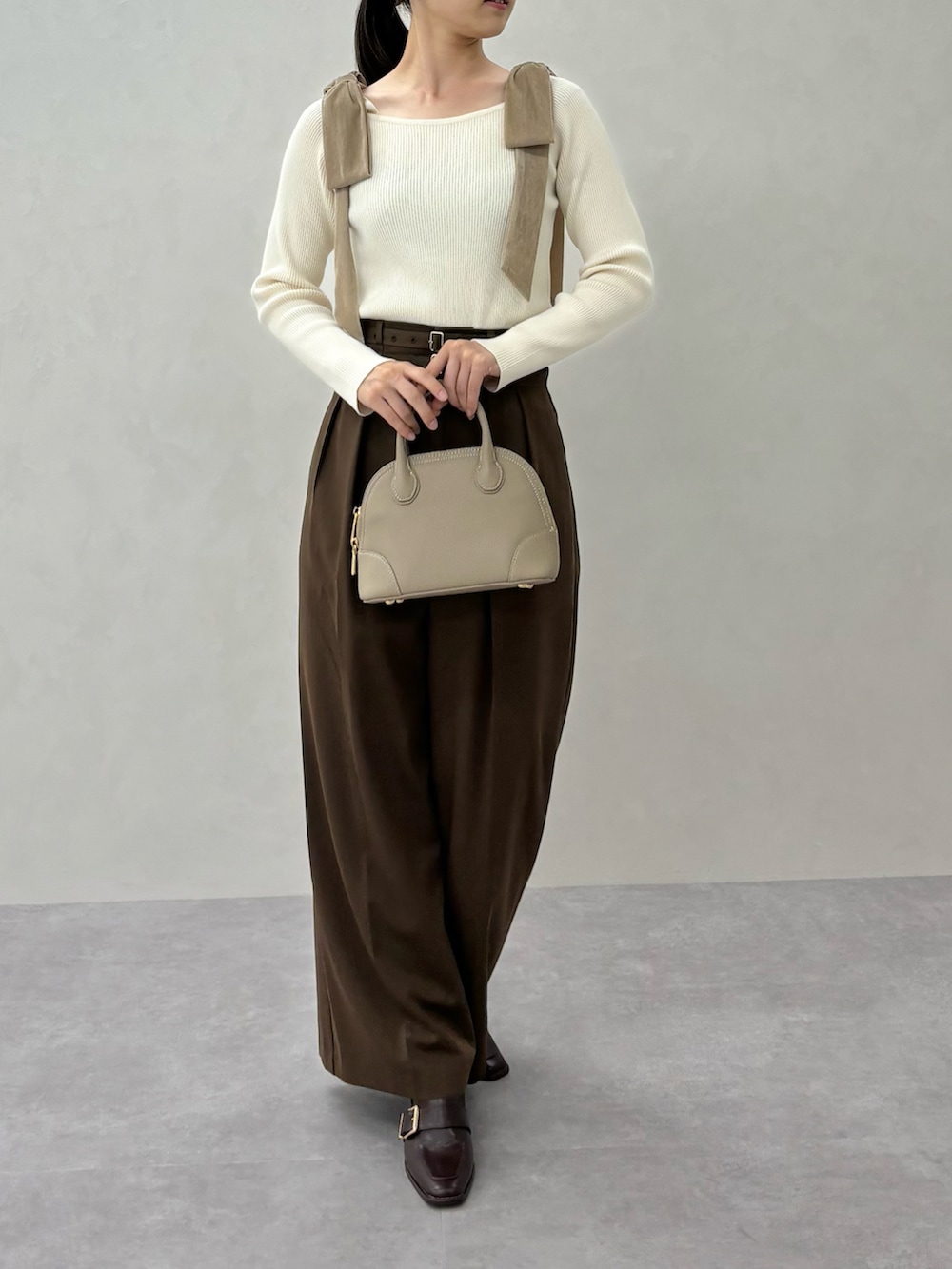 ベージュ系のニット/セーター、ブラウン系のスラックス、ブラウン系のパンプスを着用したレディースの秋コーディネートの4枚目の写真