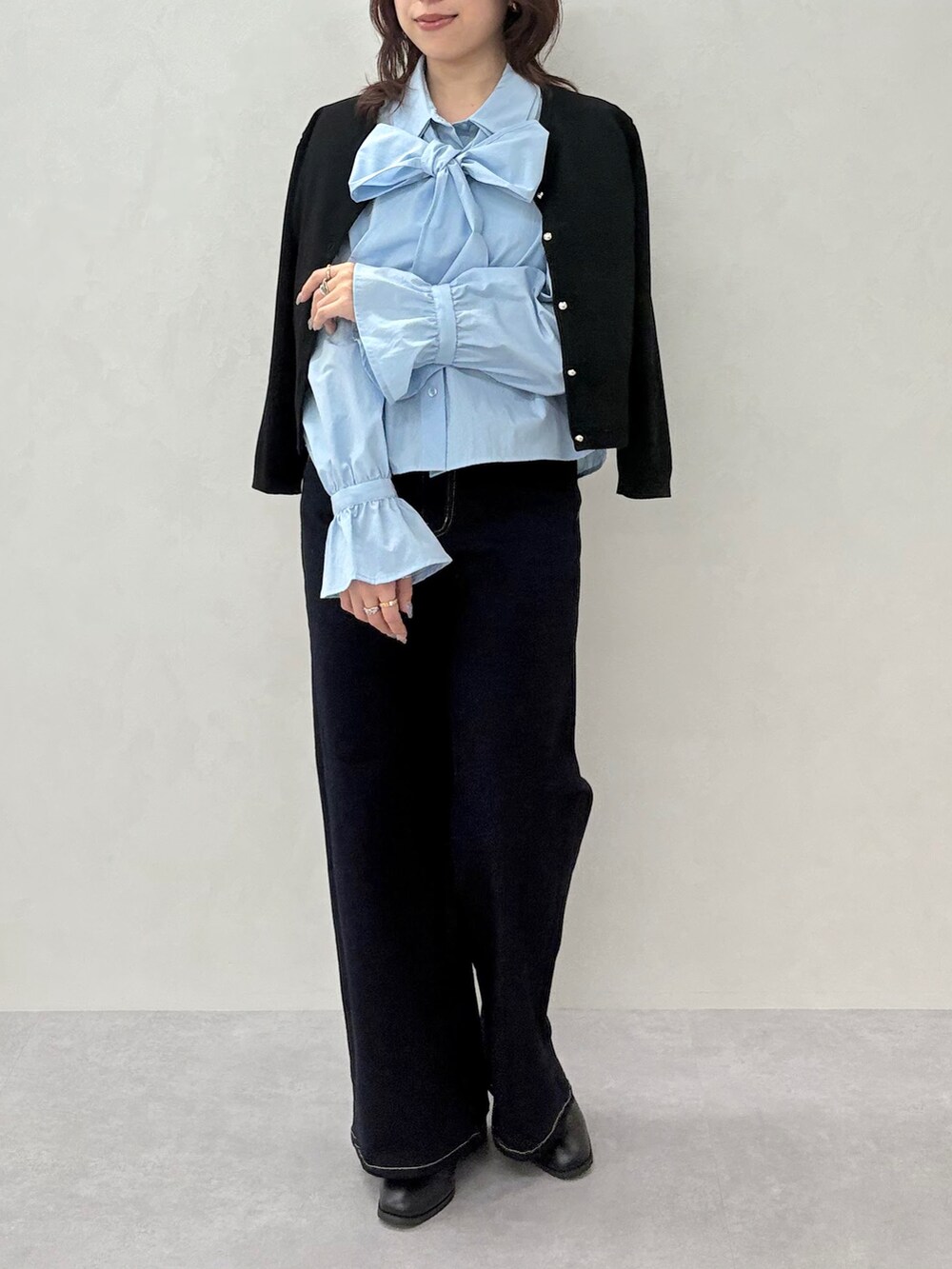 ブルー系のデニムパンツ、ブラック系のカーディガン/ボレロ、ブルー系のシャツ/ブラウスを着用したレディースの秋コーディネートの2枚目の写真